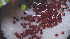 將炒好的食材和大米、紅豆一起放進(jìn)電飯鍋煮。
