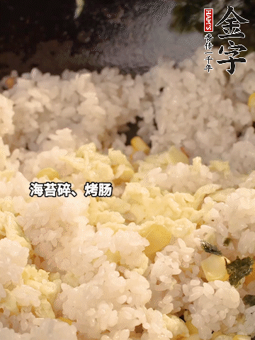 剩米飯下鍋炒散，依次下玉米粒、雞蛋、烤腸、海苔碎翻炒均勻。