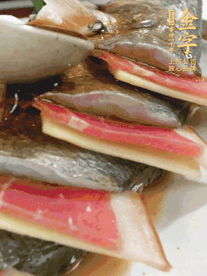 魚肚中塞蔥結(jié)、火腿片，魚身上碼放姜片、火腿片，倒入混合的料汁。